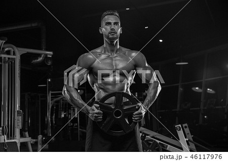 Handsome man with big muscles, posing at the camera in the gym 46117976