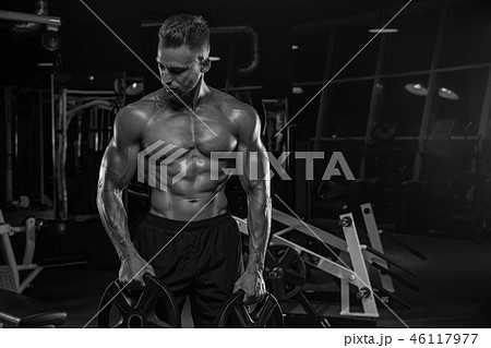 Handsome man with big muscles, posing at the camera in the gym 46117977