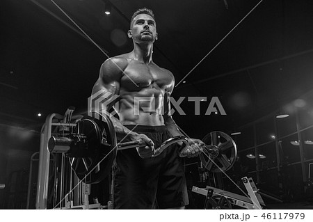 Handsome man with big muscles, posing at the camera in the gym 46117979