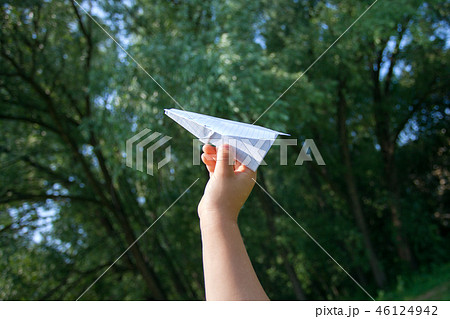 Paper airplane in children hands on greenery Paper airplane in children hands on greenery 46124942