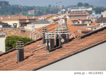 Old clay chimney pots and brick chimney stacks on old tiled roof complete with TV aerials in England 46126992
