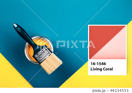 Brush on open can of Living Coral paint on blue pastel background 46134553
