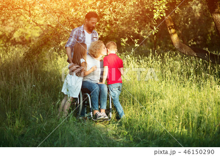 Woman in wheelchair kisses her son among family members 46150290