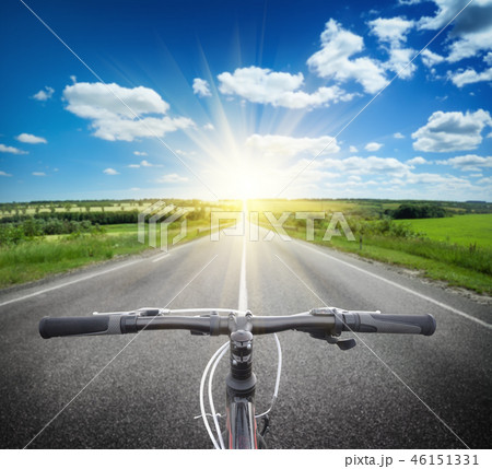 Bicycle handlebar on the background of road to bright sun 46151331
