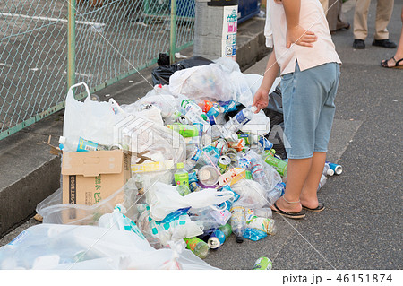 ごみ箱から溢れたゴミを拾う少年 46151874