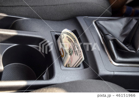 Several banknotes American dollars lie in the niche of the central console of the car. The money in 46151966