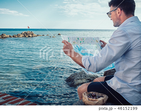 Stylish man, holding a tourist map in his hands Stylish man, holding a tourist map in his hands 46152199