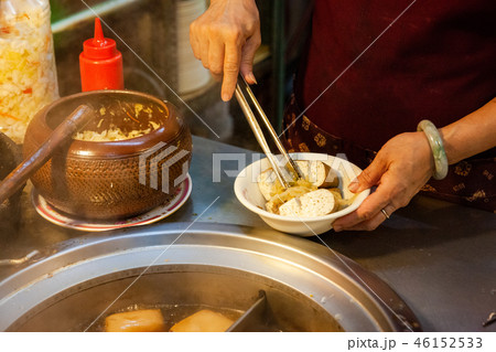 A woman serves stinky tofu at the night market 46152533