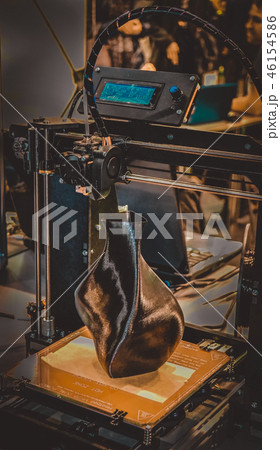 3D printer printing a model in the form of black vase close-up. 3D printer printing a model in the form of black vase close-up. 46154586