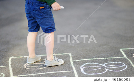 Child playing hopscotch game on playground 46166002