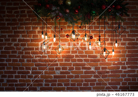 Brick wall with light bulbs and New Year's decoration Brick wall with light bulbs and New Year's decoration 46167773