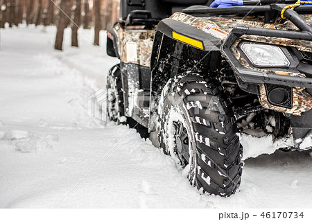 Close-up ATV 4wd quad bike in forest at winter. 4wd all-terreain vehicle stand in heavy snow with Close-up ATV 4wd quad bike in forest at winter. 4wd all-terreain vehicle stand in heavy snow with 46170734