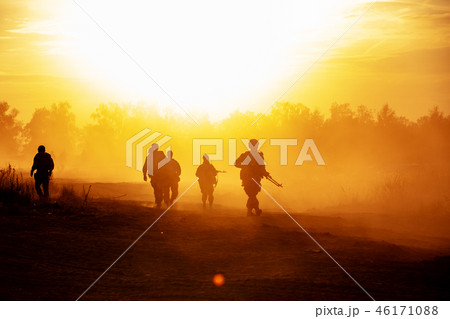 silhouette action soldiers walking hold weapons the background is smoke and sunset and white balance silhouette action soldiers walking hold weapons the background is smoke and sunset and white balance 46171088
