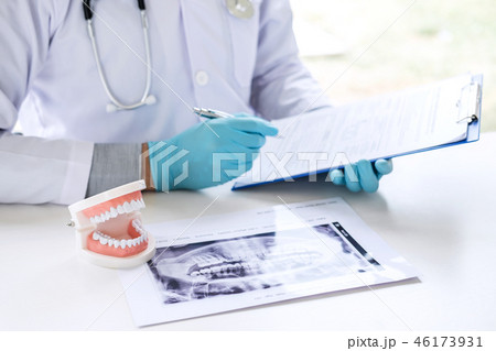 Male doctor or dentist working with report and patient tooth x-r 46173931