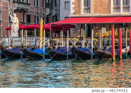 Gondolas near an italian street cafe in the Grand Canal of Venic Gondolas near an italian street cafe in the Grand Canal of Venic 46174422