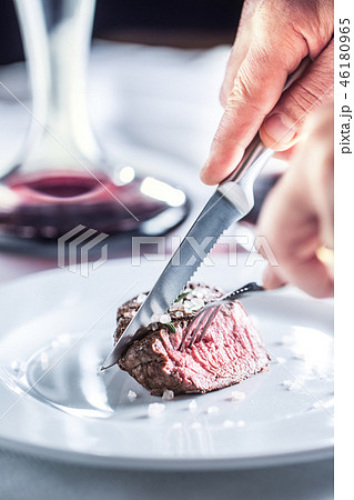 Beef tenderloin steak on white plate and red wine. Beef tenderloin steak on white plate and red wine. 46180965