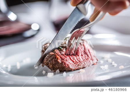 Beef tenderloin steak on white plate and red wine. Beef tenderloin steak on white plate and red wine. 46180966