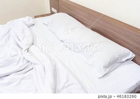 Messy bed. White pillow with blanket on bed unmade Messy bed. White pillow with blanket on bed unmade 46183260