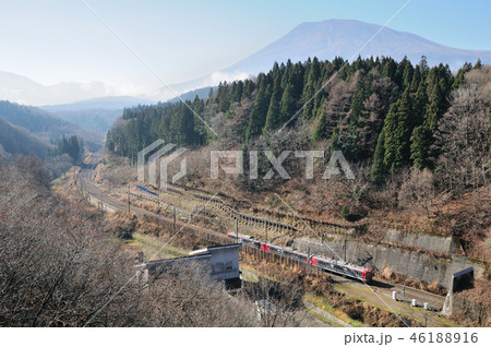 黒姫山を背景に冬枯れの山間を行くしなの鉄道115系電車 46188916