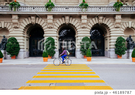 Woman riding a bike pass Swiss Parliament building 46189787