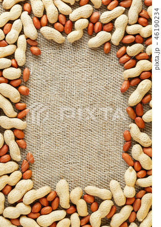 Roasted peanuts in a shell and peeled on a brown Roasted peanuts in a shell and peeled on a brown 46190234