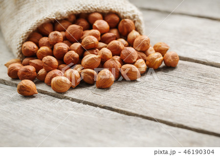 Chiselled hazelnuts in a bag of burlap on a gray Chiselled hazelnuts in a bag of burlap on a gray 46190304