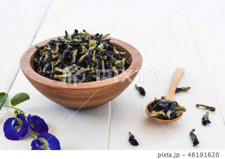 Pea flowers dry in bowl on white wooden background 46191620