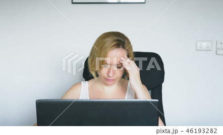 A woman using her laptop sits at the table, angry and annoyed. Human emotions. Internet addiction. 46193282