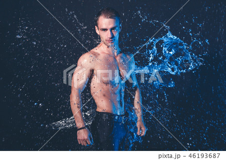 Fresh portrait of muscular man with water splashes on dark background. Fresh portrait of muscular man with water splashes on dark background. 46193687