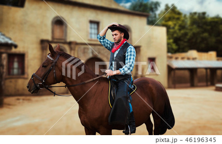 Cowboy riding a horse in texas country, saloon Cowboy riding a horse in texas country, saloon 46196345