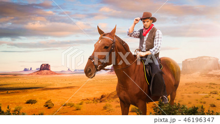 Cowboy riding a horse in desert valley, western 46196347