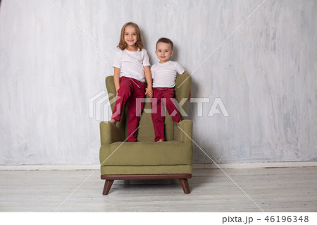 little boy and girl are brother and sister sit on a green Chair little boy and girl are brother and sister sit on a green Chair 46196348