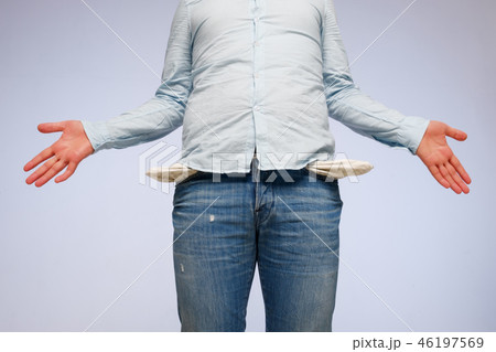A white man shows empty jeans pockets. A white man shows empty jeans pockets. 46197569
