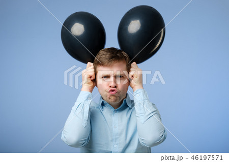 unhappy man holding black balloons in the head unhappy man holding black balloons in the head 46197571