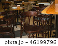 Wooden tables and chairs in the cafe. It's dark. 46199796