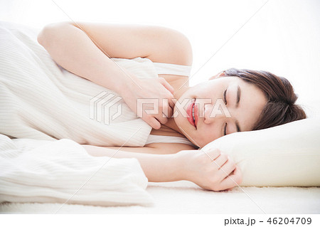女性 寝る 睡眠 朝 若い女性 かわいい ライフスタイルの写真素材