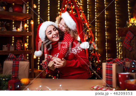 Cheerful cute little girl and her older sister exchanging gifts. 46209353