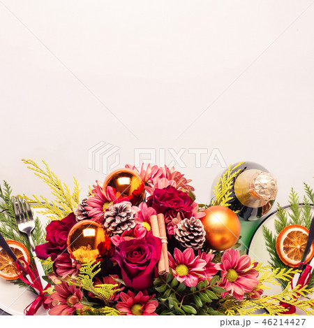 Christmas table setting decorated with bouquet of flowers, sprigs of thuja and dry oranges Christmas table setting decorated with bouquet of flowers, sprigs of thuja and dry oranges 46214427