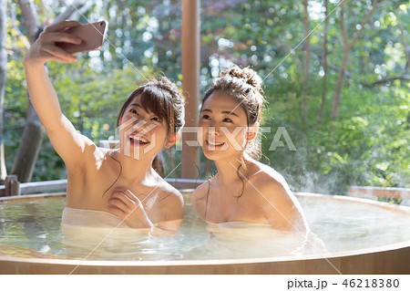 若い女性 女子旅 温泉 露天風呂 スマホの写真素材