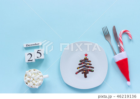 Xmas composition Calendar December 25th. Sweet chocolate Christmas tree on plate, cutlery in santa 46219136