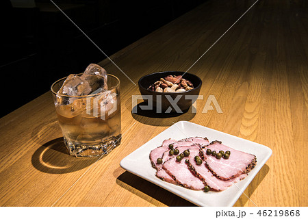 バーでウイスキーのロック ミックスナッツとペッパーハムのグリーンペッパー載せとともに バーでウイスキーのロック ミックスナッツとペッパーハムのグリーンペッパー載せとともに 46219868