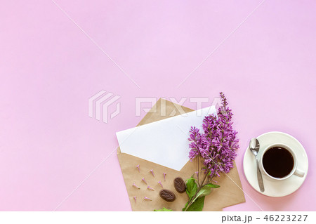 Branch of lilac on craft envelope with white empty blank card for text and cup of coffee, pink Branch of lilac on craft envelope with white empty blank card for text and cup of coffee, pink 46223227