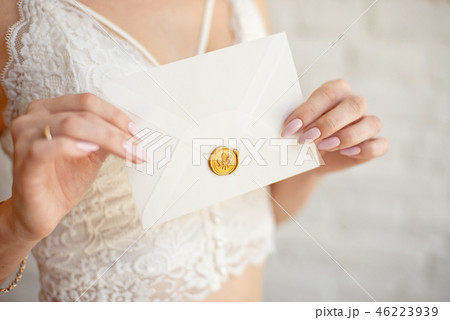 Closeup woman with slim body in lace underwear holding invitation card in hand, back view Closeup woman with slim body in lace underwear holding invitation card in hand, back view 46223939