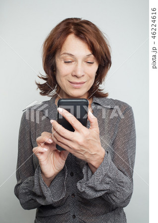 Mature woman texting on white background Mature woman texting on white background 46224616