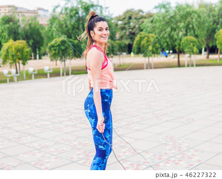 Fit beautiful woman with jumping rope in a park Fit beautiful woman with jumping rope in a park 46227322