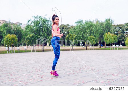 Fit beautiful woman with jumping rope in a park 46227325