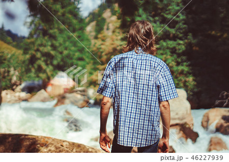 the guy stands at the mountain river 46227939