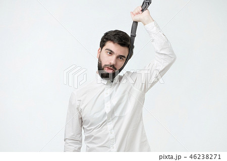 man in white shirt strangling himself tie. man in white shirt strangling himself tie. 46238271