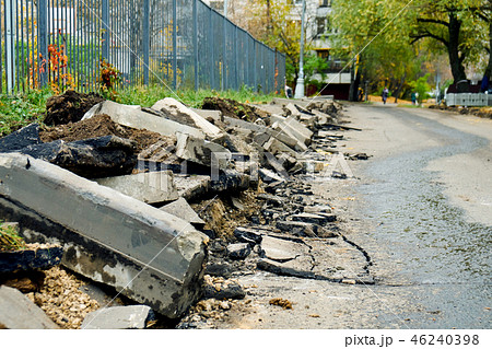 Broken freshly dug up old curbstones with pieces of an asphalt and earth lying on the road in Moscow Broken freshly dug up old curbstones with pieces of an asphalt and earth lying on the road in Moscow 46240398