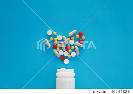 Pills heart out of pill bottle on blue background. Pills heart out of pill bottle on blue background. 46244828
